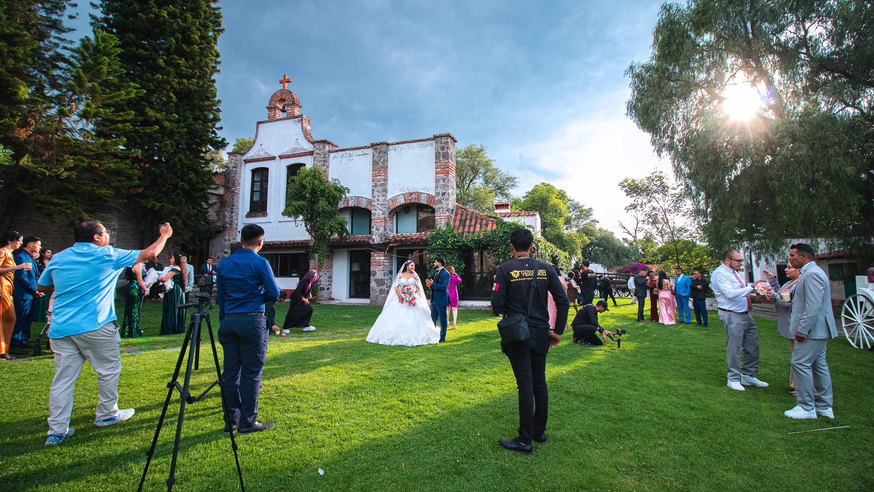 Equipo de videografía filmando una boda en una hacienda: dos camarógrafos con cámaras de cine y operador de drone